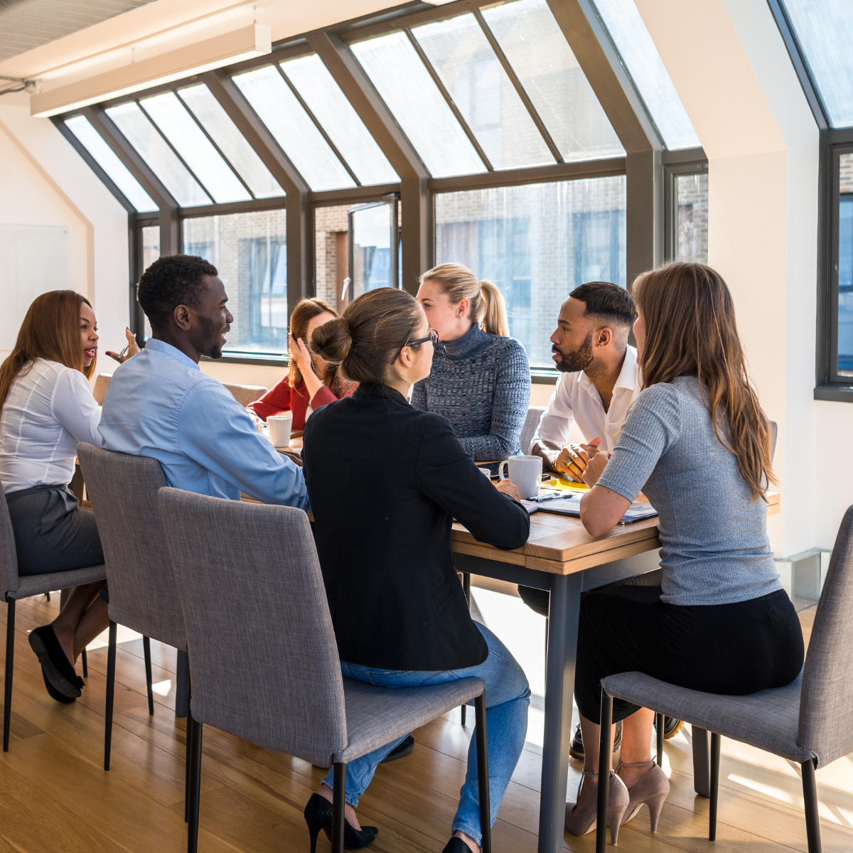 A group of people sitting around a table talking