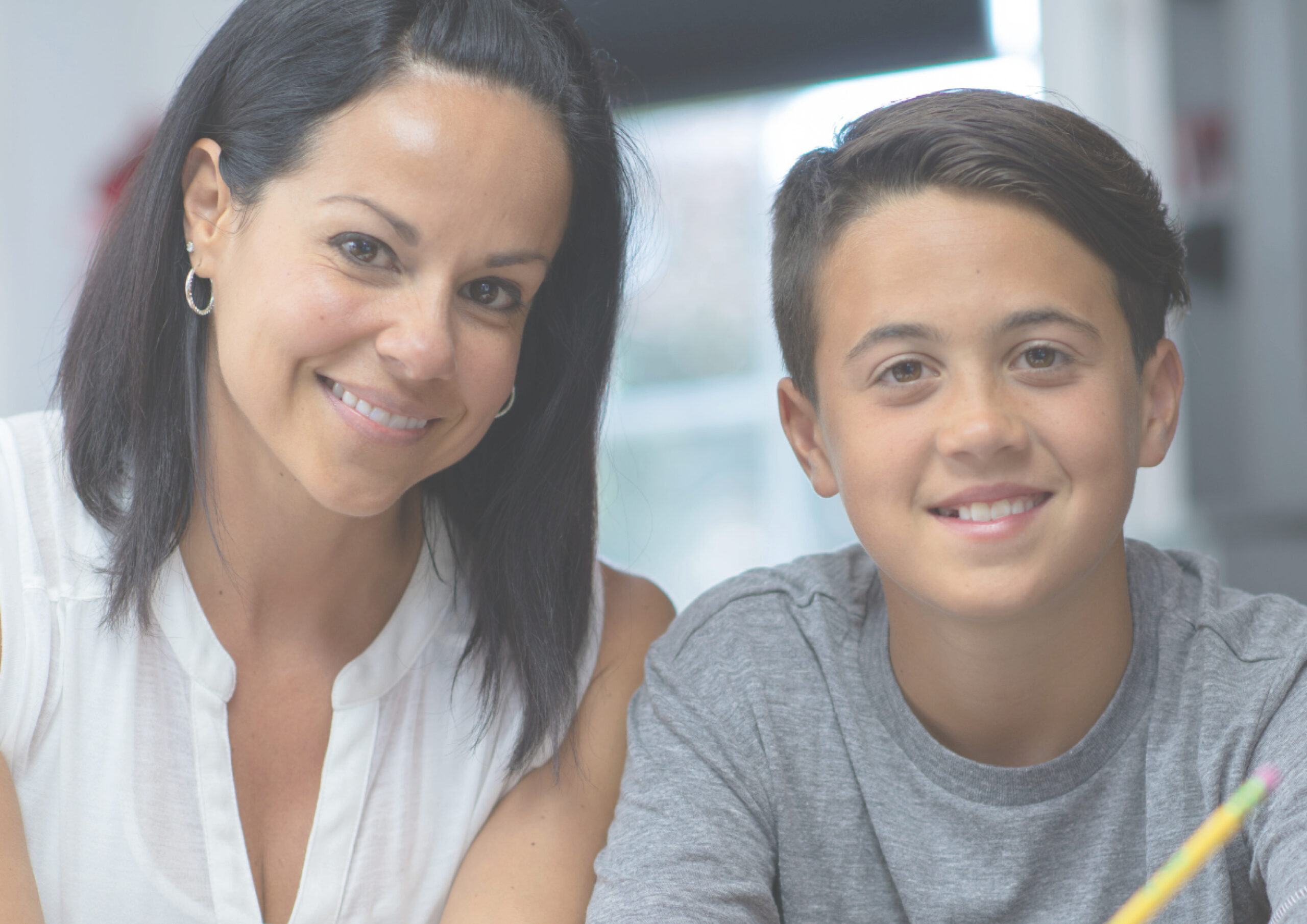 Smiling woman sitting next to smiling teenage boy