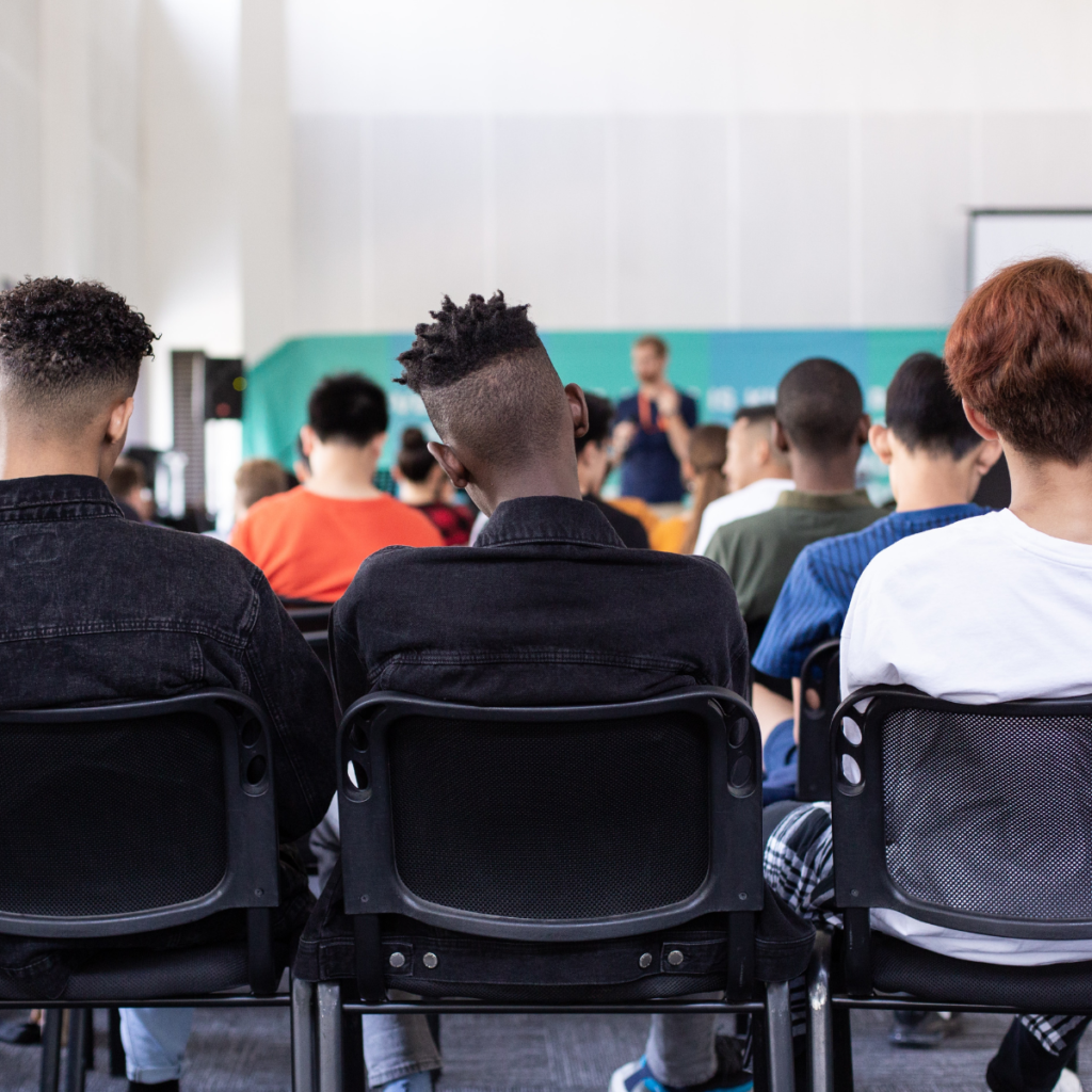 Backs of teenagers in an assembly