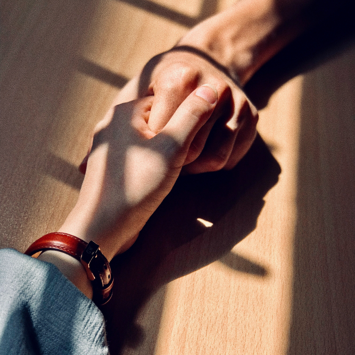 Two hands holding across a table