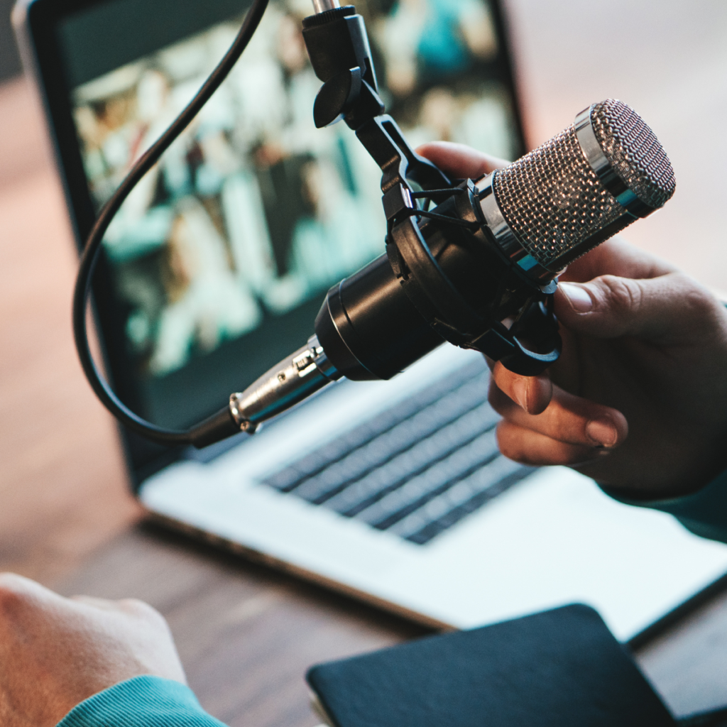 A man holding a microphone for a podcast recording